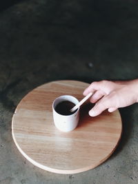 High angle view of hand holding coffee cup