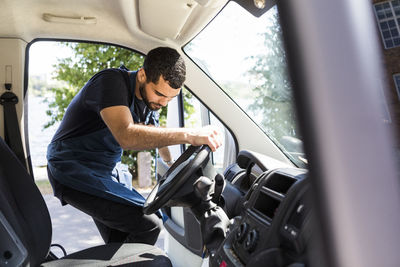 Side view of man sitting in car