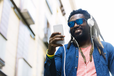 Young man using mobile phone in city