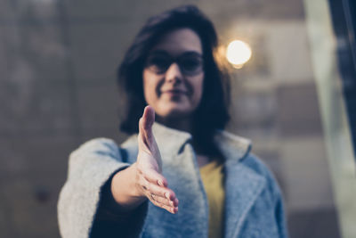 Portrait of woman giving hand