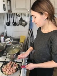 Midsection of woman having food at home