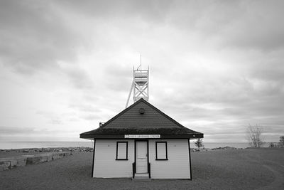 Lifeguard hut on beach by sea against sky