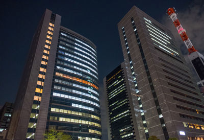 Low angle view of illuminated buildings against sky at night