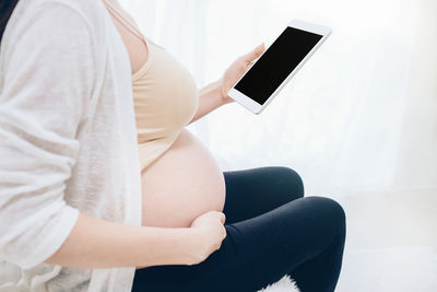 Midsection of man using mobile phone