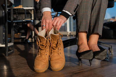 Low section of woman holding shoes