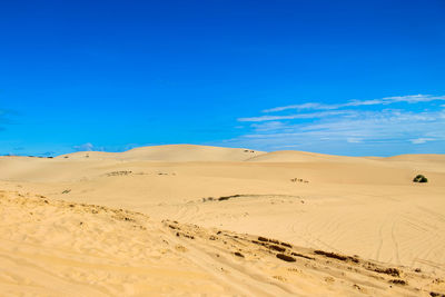 Scenic view of desert against blue sky