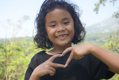 Smiling little girl gestured hand of peace and love symbol