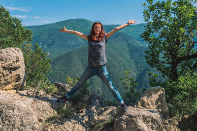 Full length of young woman standing on rock