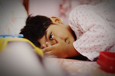 Portrait of woman lying on bed at home