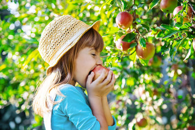 Side view of girl eating apple