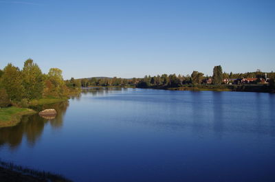 Scenic view of lake against clear blue sky