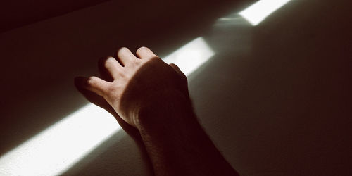 Low section of person with shadow on wall