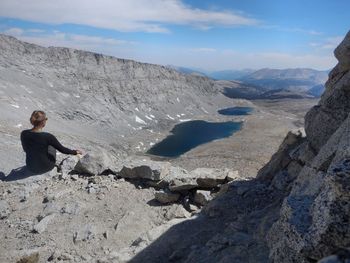 Man sitting on rock against mountains