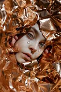 Close-up portrait of young woman with leaves