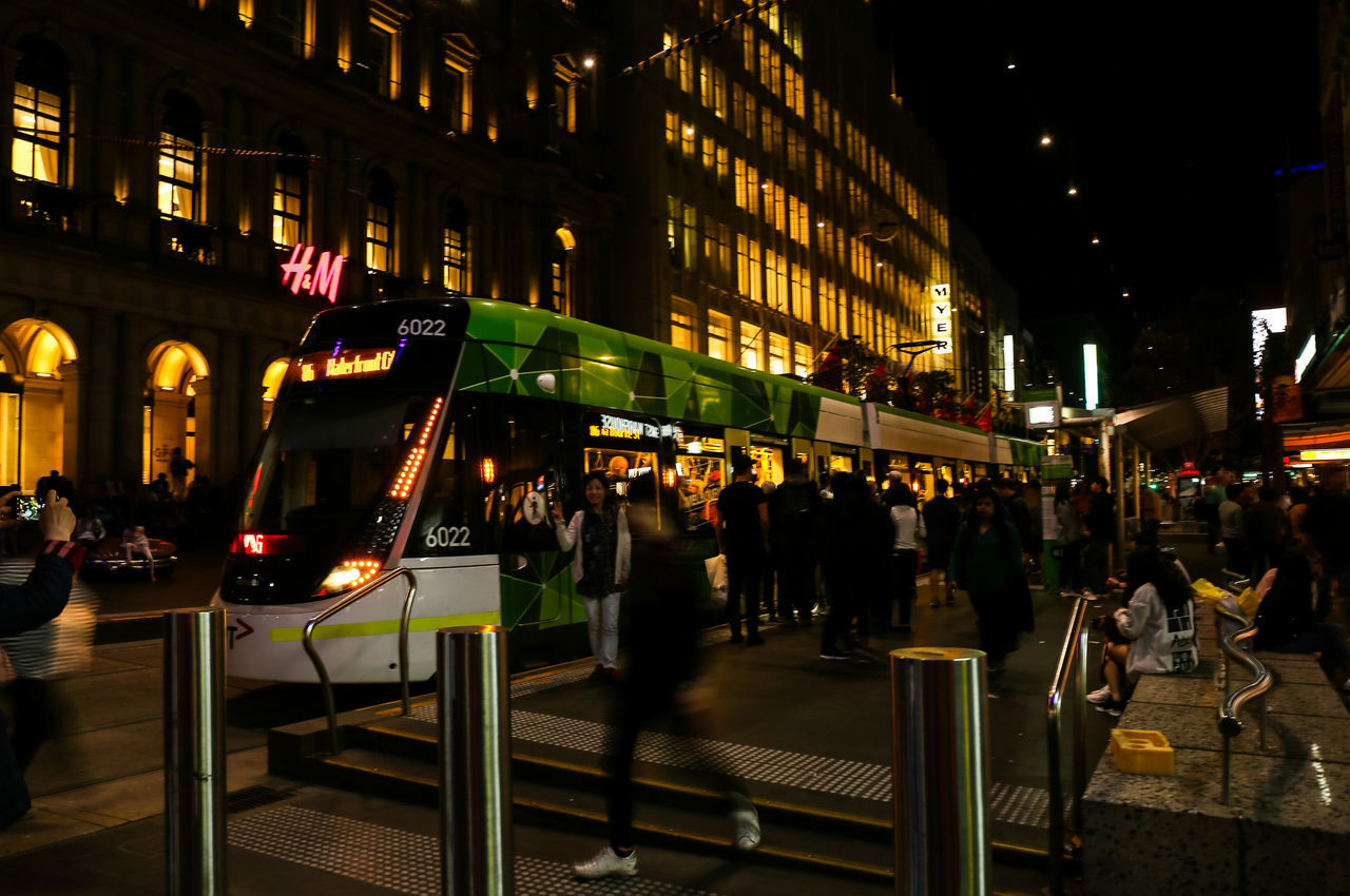 PEOPLE WALKING ON STREET AT NIGHT