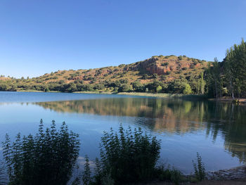 Scenic view of lake against clear blue sky