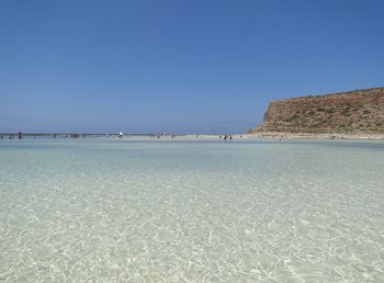 Scenic view of beach against clear blue sky