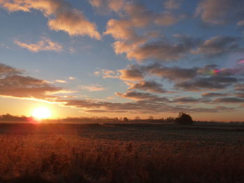 Scenic view of field against sky during sunset