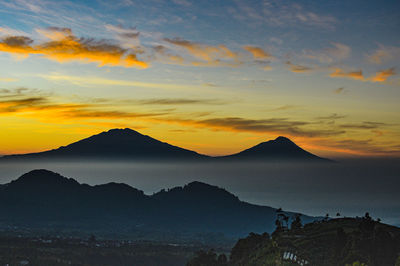 Scenic view of silhouette mountains against sky at sunset