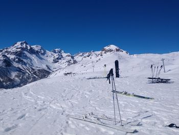 View of people skiing on snowcapped mountain against blue sky