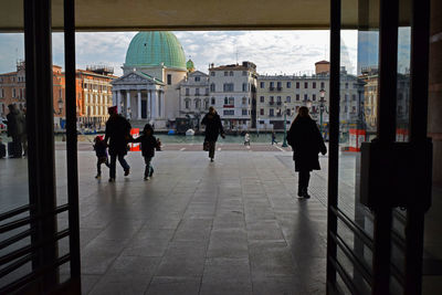 People walking by buildings in city