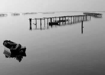 Wooden posts on pier over sea against sky