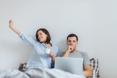 Couple waking up on bed at home