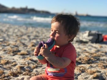 Boy on beach against sky