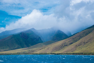 Scenic view of lake by mountains against sky