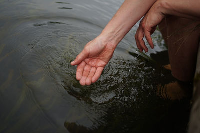 High angle view of woman touching water