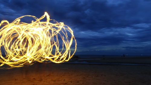 Light painting on beach against sky at night