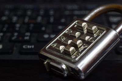 Close-up of metallic padlock by computer keyboard on table