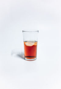 Glass of drink against white background