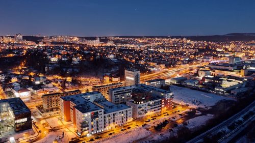 High angle view of illuminated city against sky at dusk