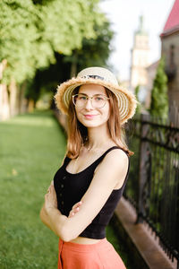 Portrait of young woman wearing hat standing outdoors