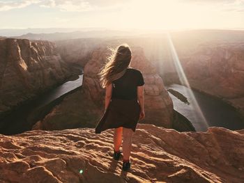 Rear view of woman on mountain during sunset