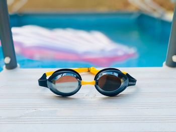 Close-up of sunglasses on table by swimming pool
