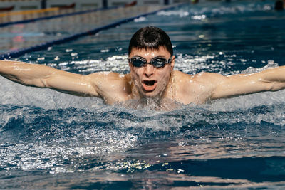 Portrait of young man swimming in pool