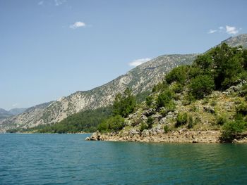 Scenic view of sea and mountains against sky