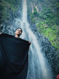 Man looking at waterfall