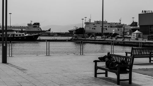 Boats moored at harbor against clear sky