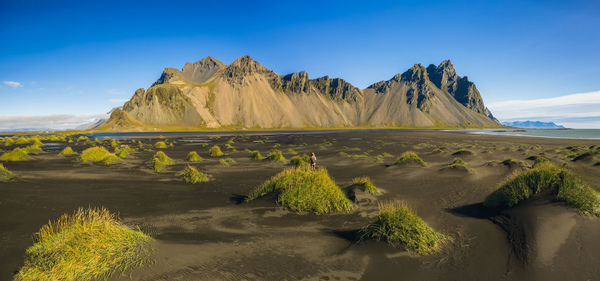 Scenic view of mountains against blue sky