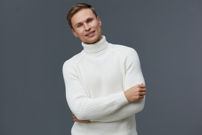 Portrait of young man standing against blue background