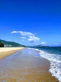 Scenic view of beach against blue sky