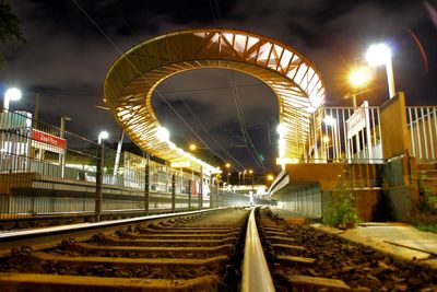 Illuminated railroad tracks at night