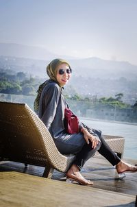 Portrait of smiling young woman sitting on mountain