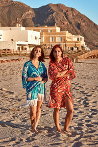 Two girls in kimonos watching on camera on the beach. fashion concept