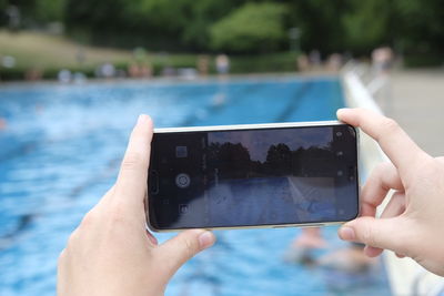 Cropped image of person photographing in swimming pool