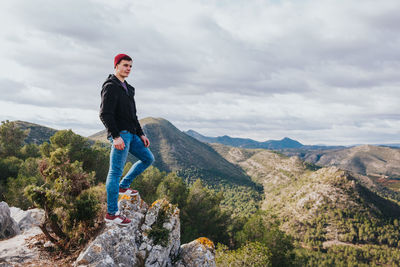 Man standing on mountain against sky