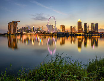 Reflection of buildings and ferris wheel in river